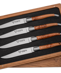 Four Laguiole en Aubrac steak knives with brown burl wood handles, presented in a wooden gift box with a black foam insert.